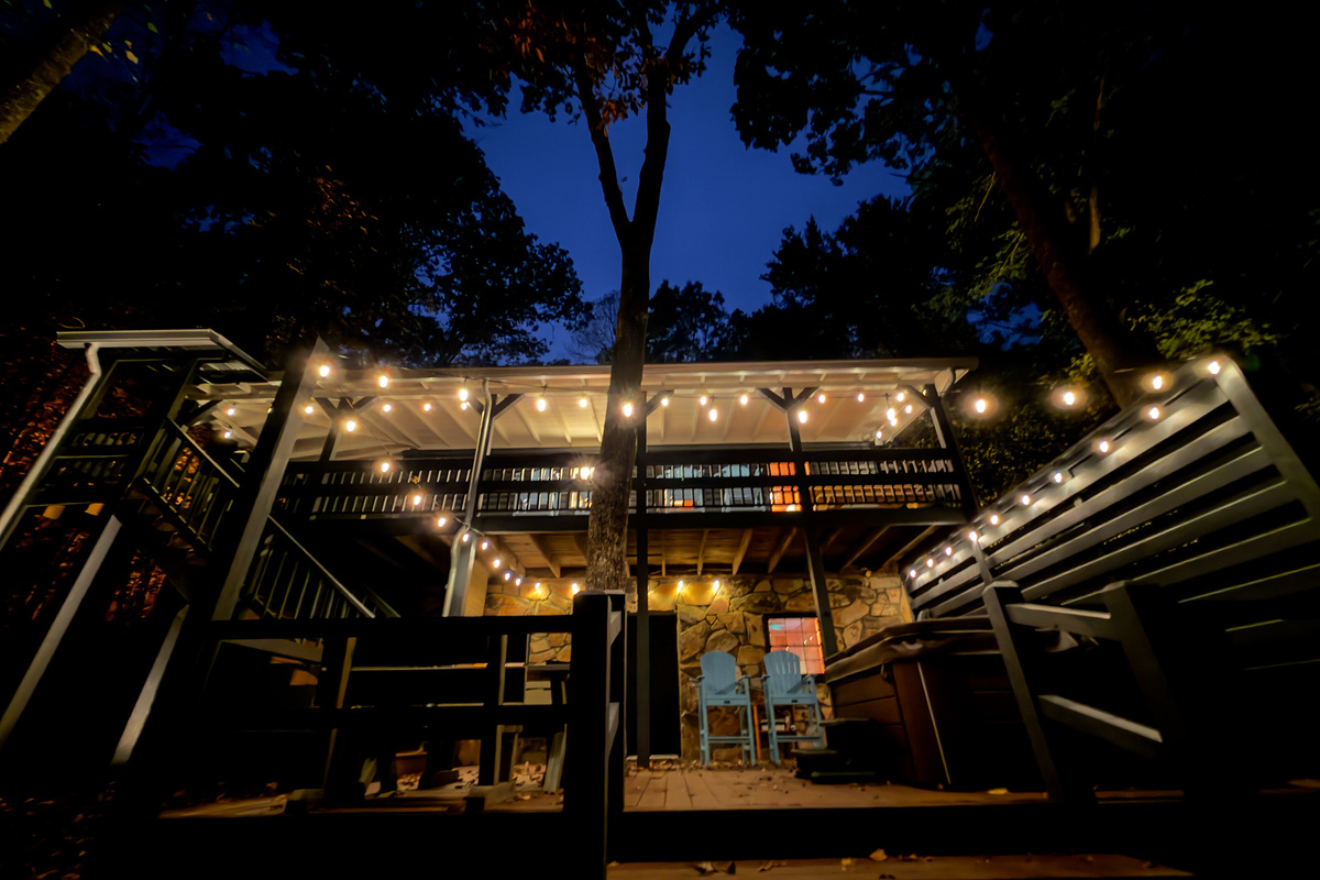 Deck lit with string lights at night.