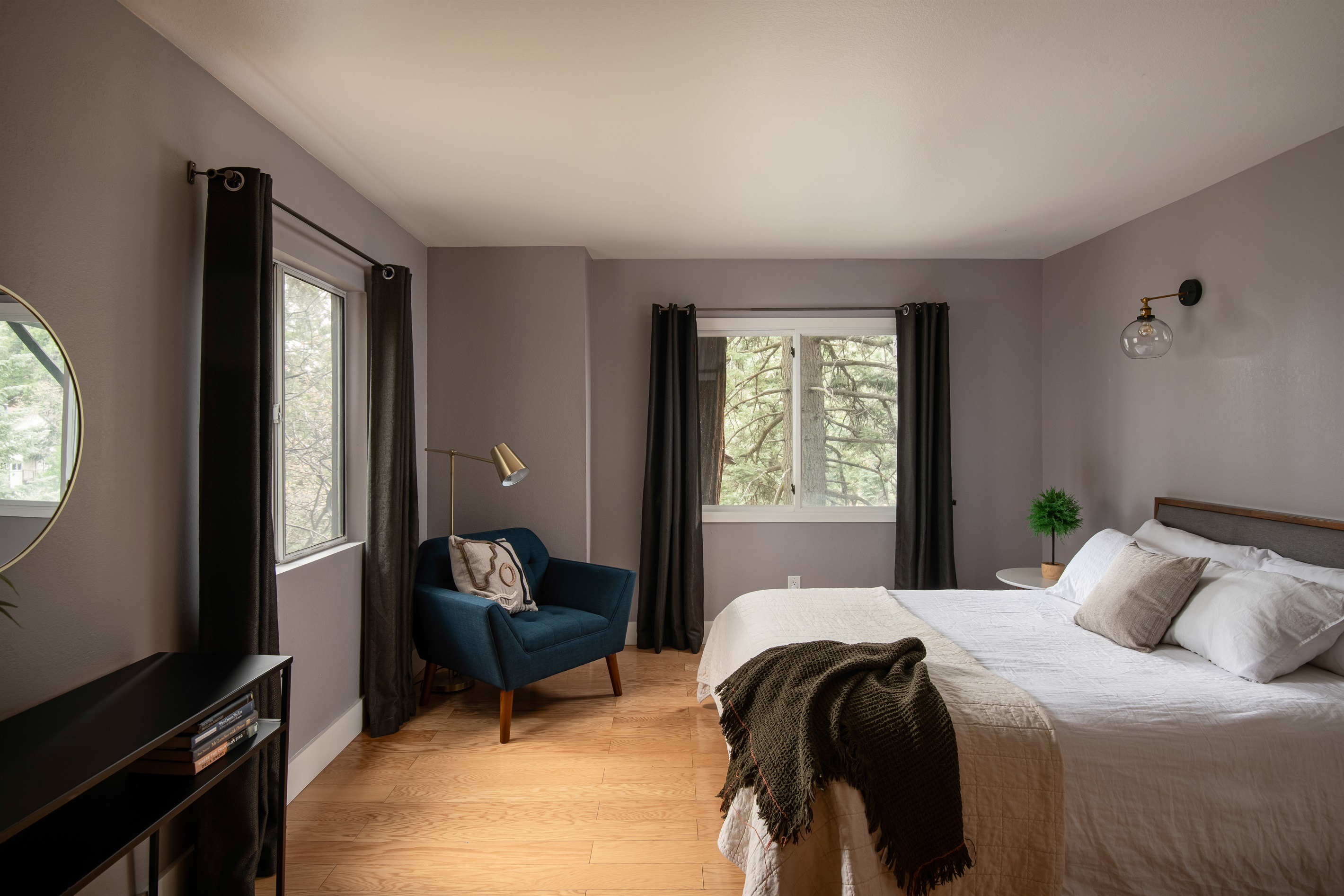 Spacious bedroom with natural light and forest views—comfortable, quiet space for restful nights during your Lake Arrowhead cabin stay.