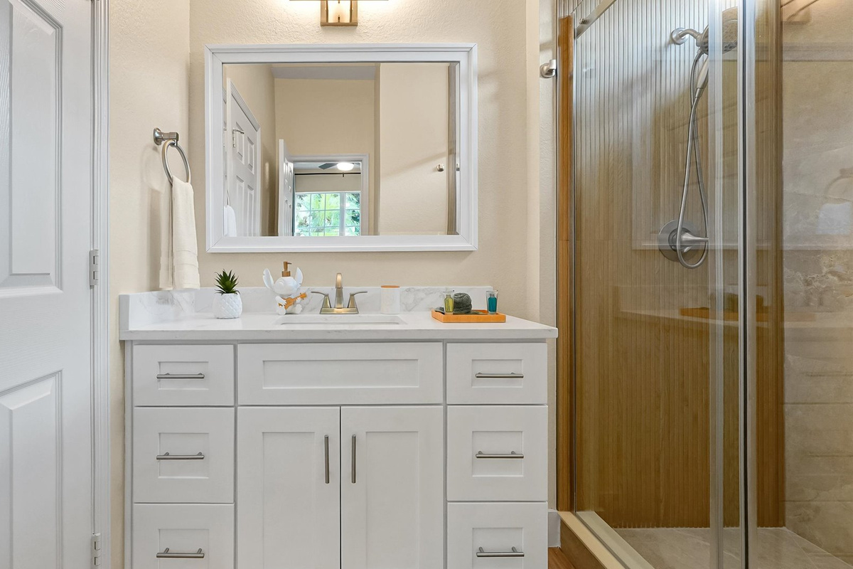Stitch Queen Retreat Ensuite: Renovated private ensuite with a bright vanity and custom-tiled walk-in shower.