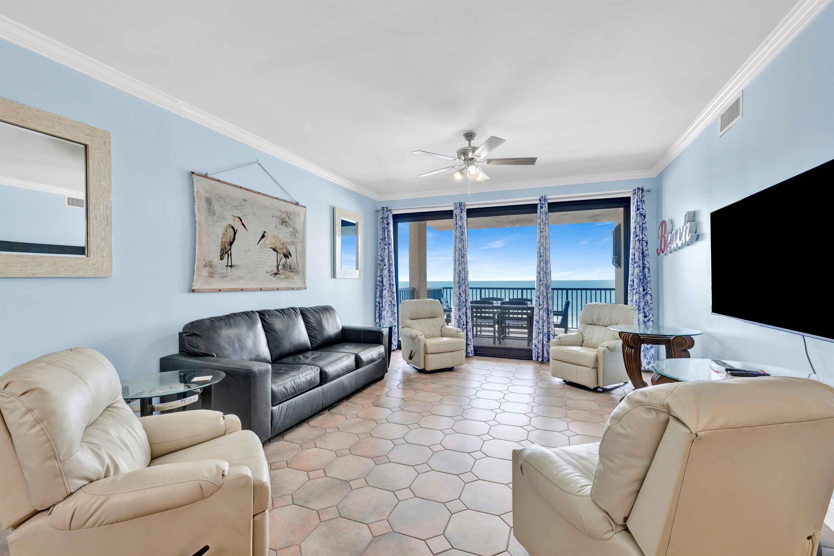 Living room with leather sleeper sofa, 4 rocking recliners, 65" wall mounted TV, breathtaking view and balcony access