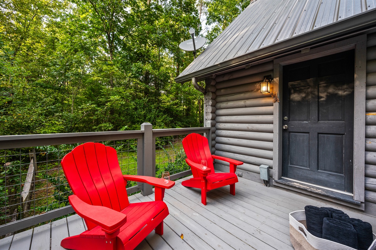 Unwind on the log cabin deck, nestled in a peaceful forest setting.