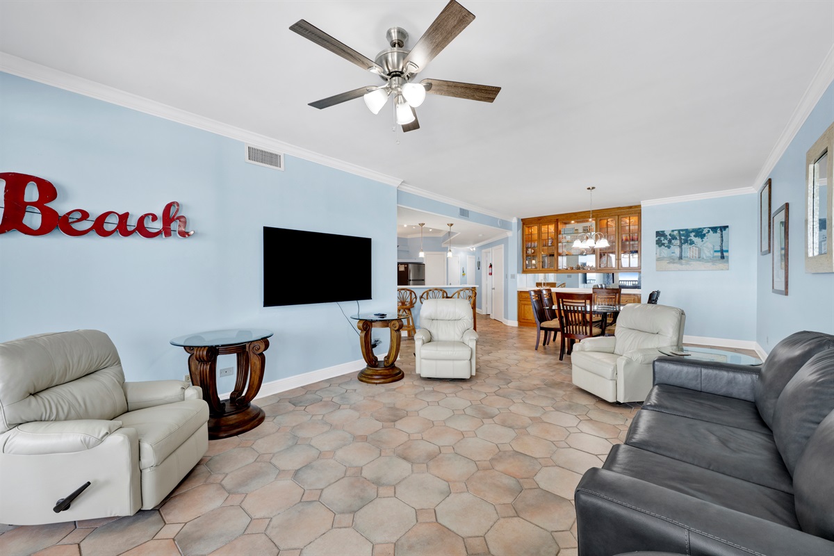 Living room with leather sleeper sofa, 4 rocking recliners, 65" wall mounted TV, breathtaking view and balcony access