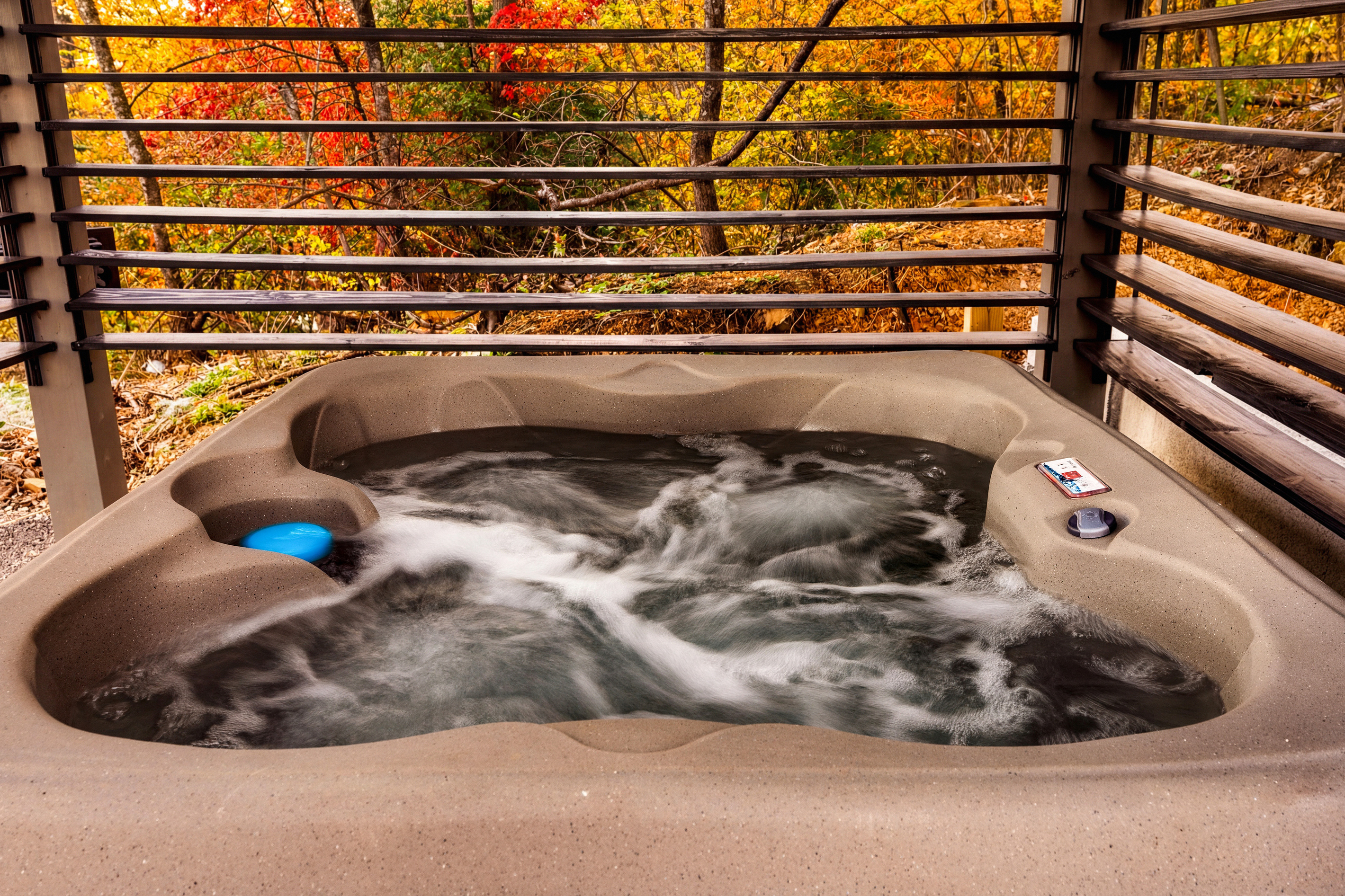 Hot tub with adjustable wooden side slats that close for privacy & decrease wind flow.