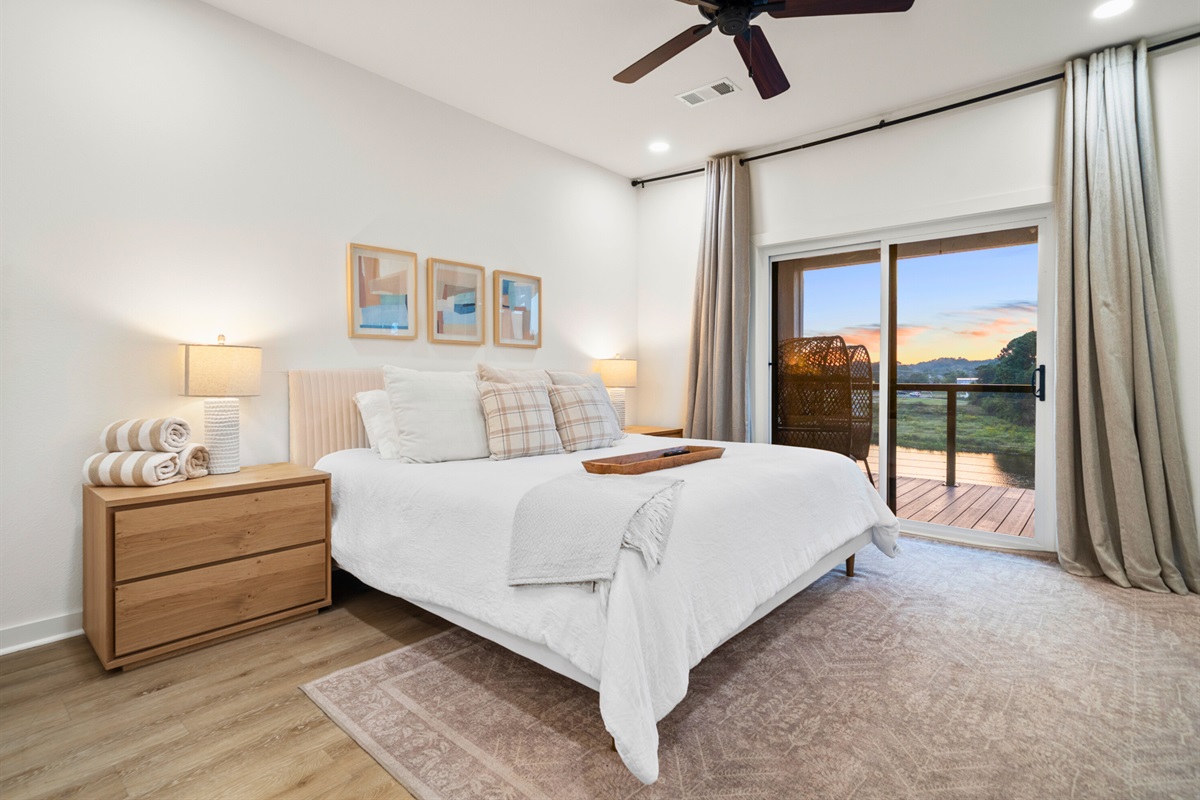 Elegant primary bedroom with lake views and calming decor for restful nights.