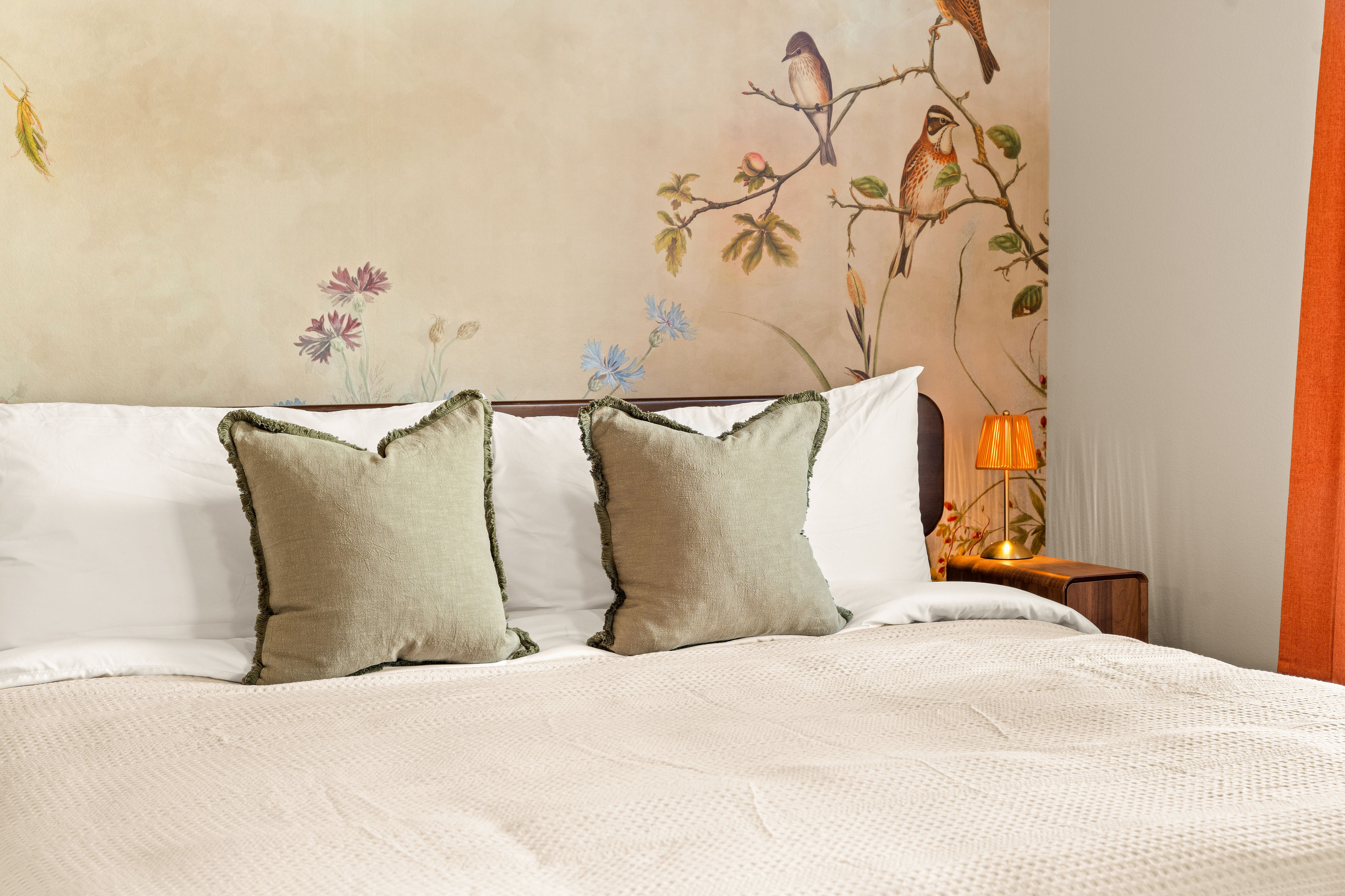 Delicate botanical artwork and soft, calming tones turn this king bedroom into a charming retreat with a touch of storybook whimsy.