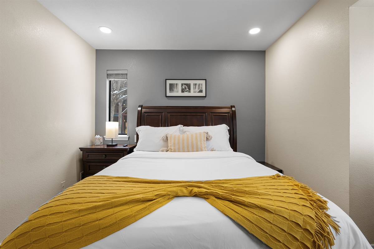 Comfortable queen bed with crisp and soft white linens, smart tv and walk in closet