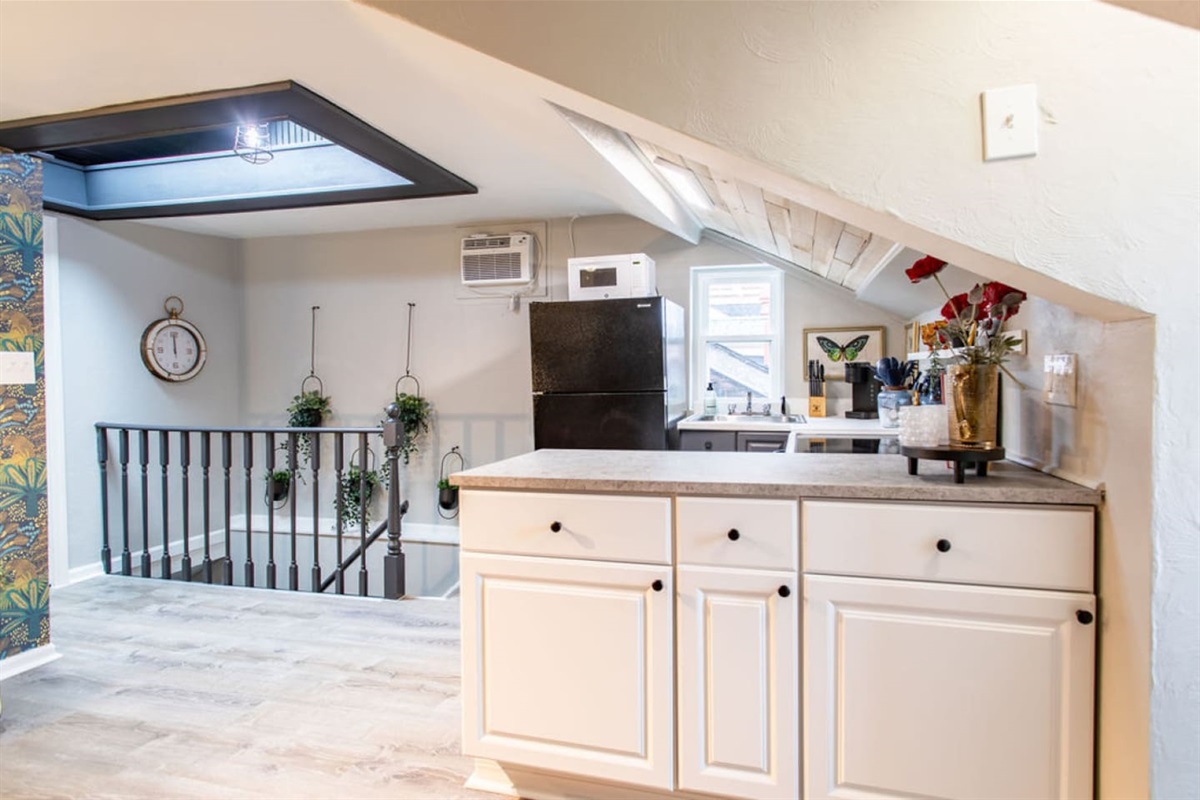 Step into a world where vintage flair meets 70's hippie chic at the top of these stairs. This open-floor plan 1-bedroom, 1-bathroom apartment boasts a kitchen and living room space that exudes funky vibes. Immerse yourself in a stylish, eclectic atmo