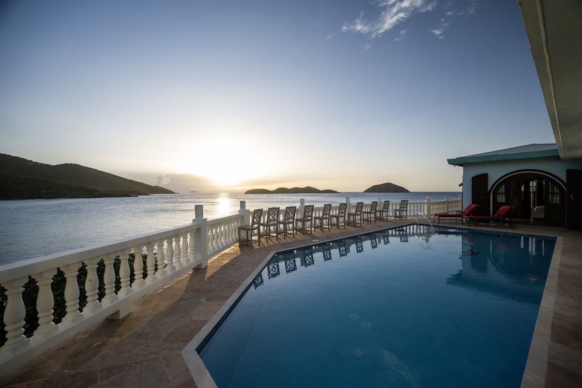 Lounge in style by the pool, surrounded by lush greenery and the sea.