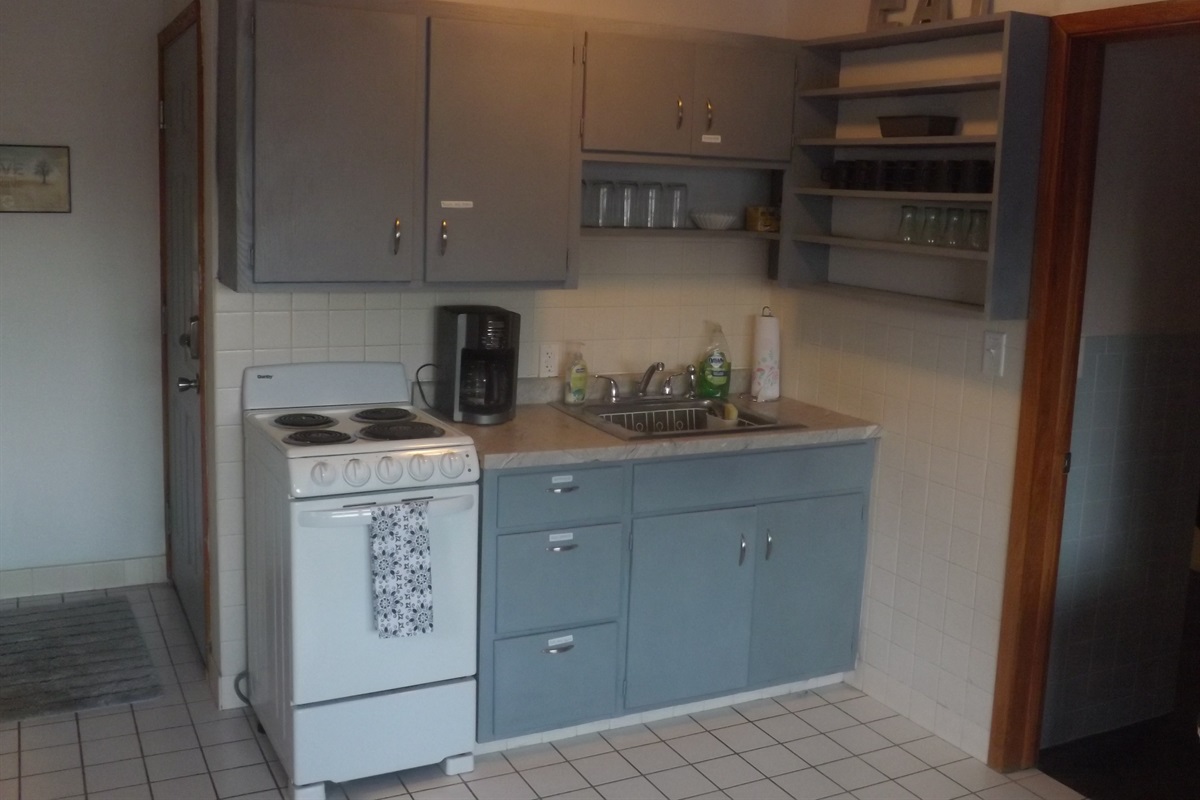 Full kitchen with refrigerator, stove, microwave, coffee makers, and most essentials