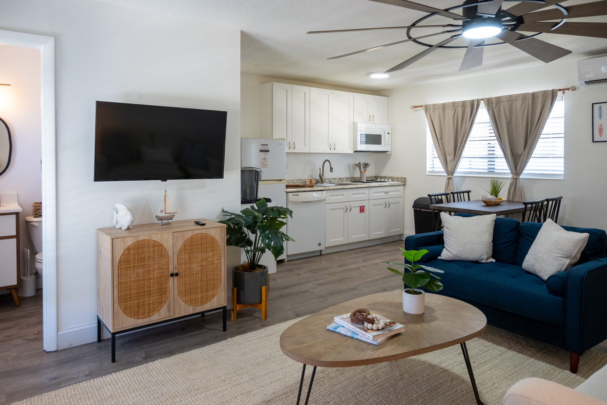 Smart TV, rattan console and full kitchen beyond