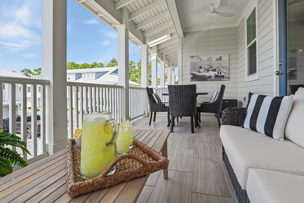 Relax on the spacious covered patio featuring a comfortable lounge area and outdoor dining. Perfect for morning coffee, curling up with a good book, sharing a meal, or unwinding with family and friends after a day at the beach.

