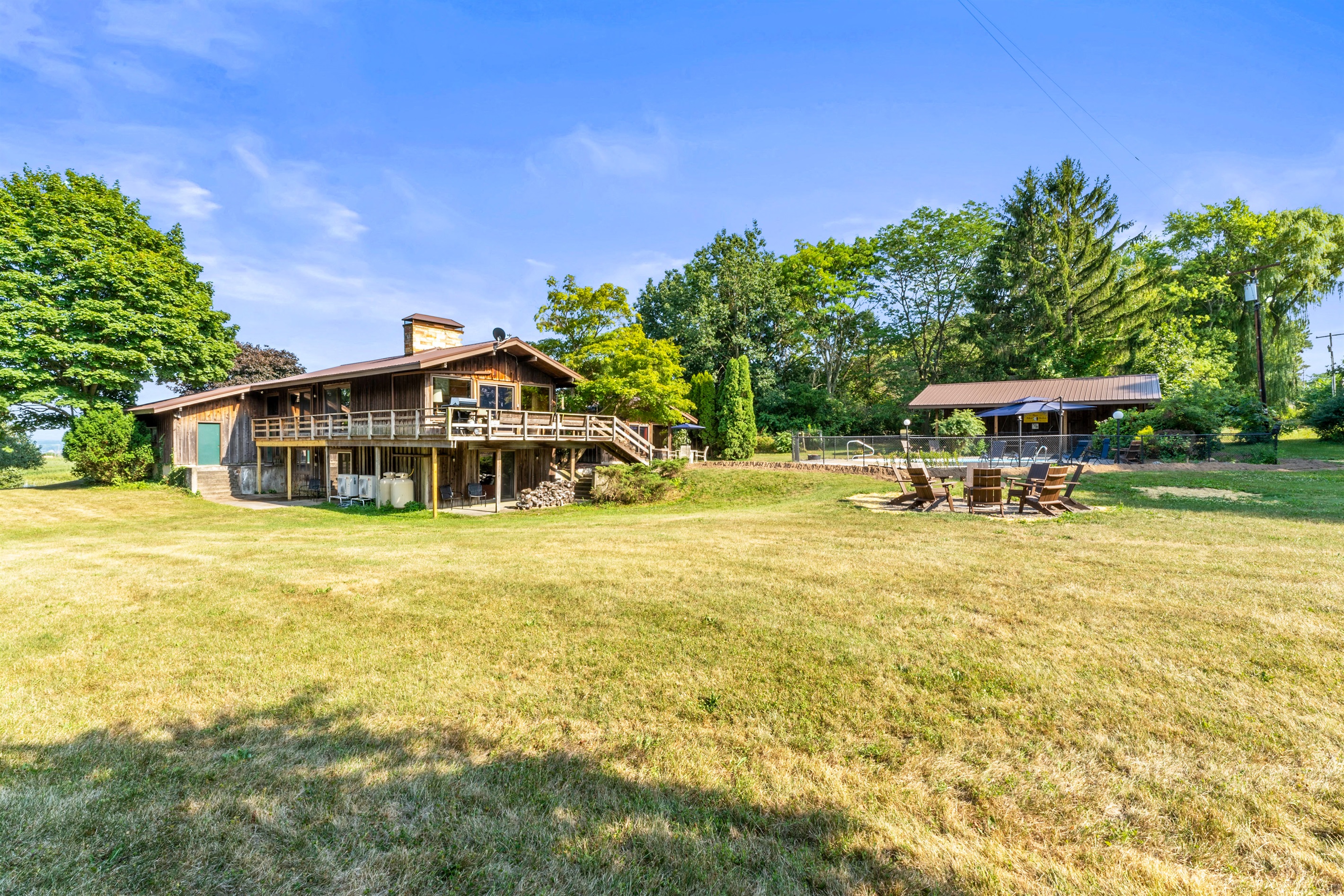 Rustic countryside retreat with a spacious deck, firepit, and wide-open yard—perfect for relaxing or gathering with friends.