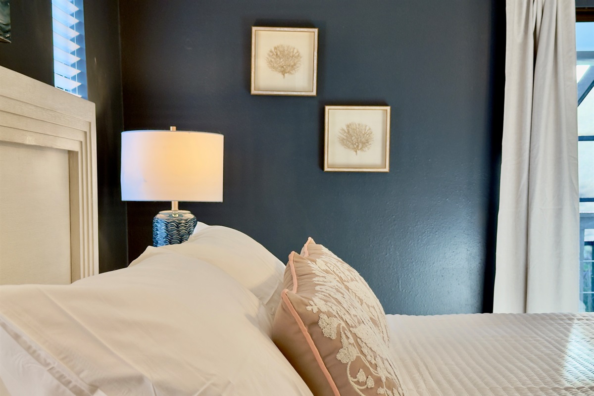 Framed artwork—including a dramatic ocean wave centerpiece—adds a serene coastal vibe that ties beautifully into the overall beachy, modern-chic aesthetic.