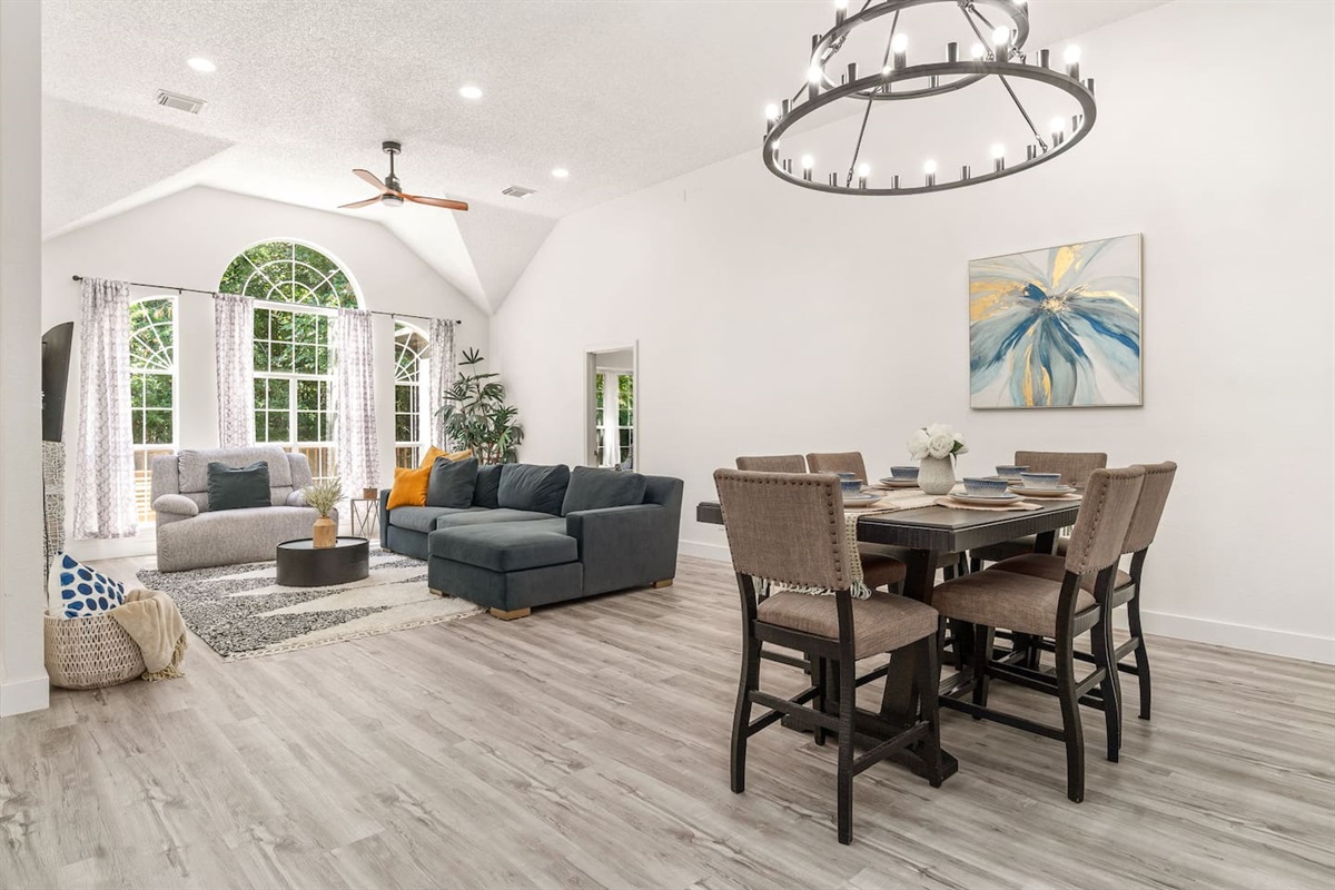 Open-concept living with dining space, seating for 6, natural light, and ceiling fan.
