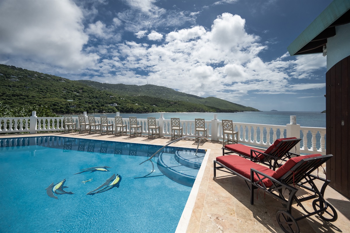 Two umbrellas have been added to the balcony to provide shade to the bar stool chairs along the pool.