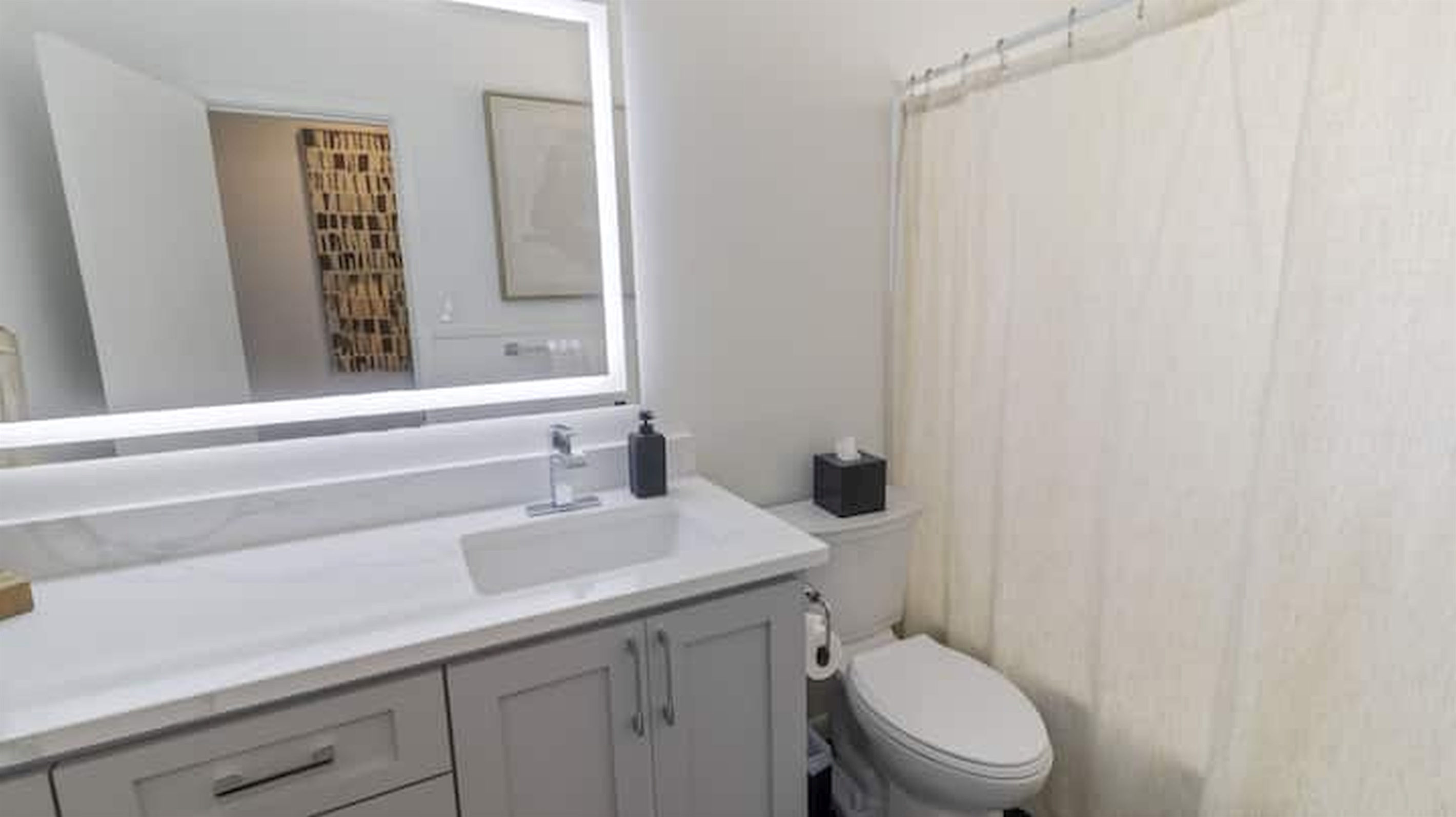 Clean and updated bathroom with modern finishes and bright lighting.