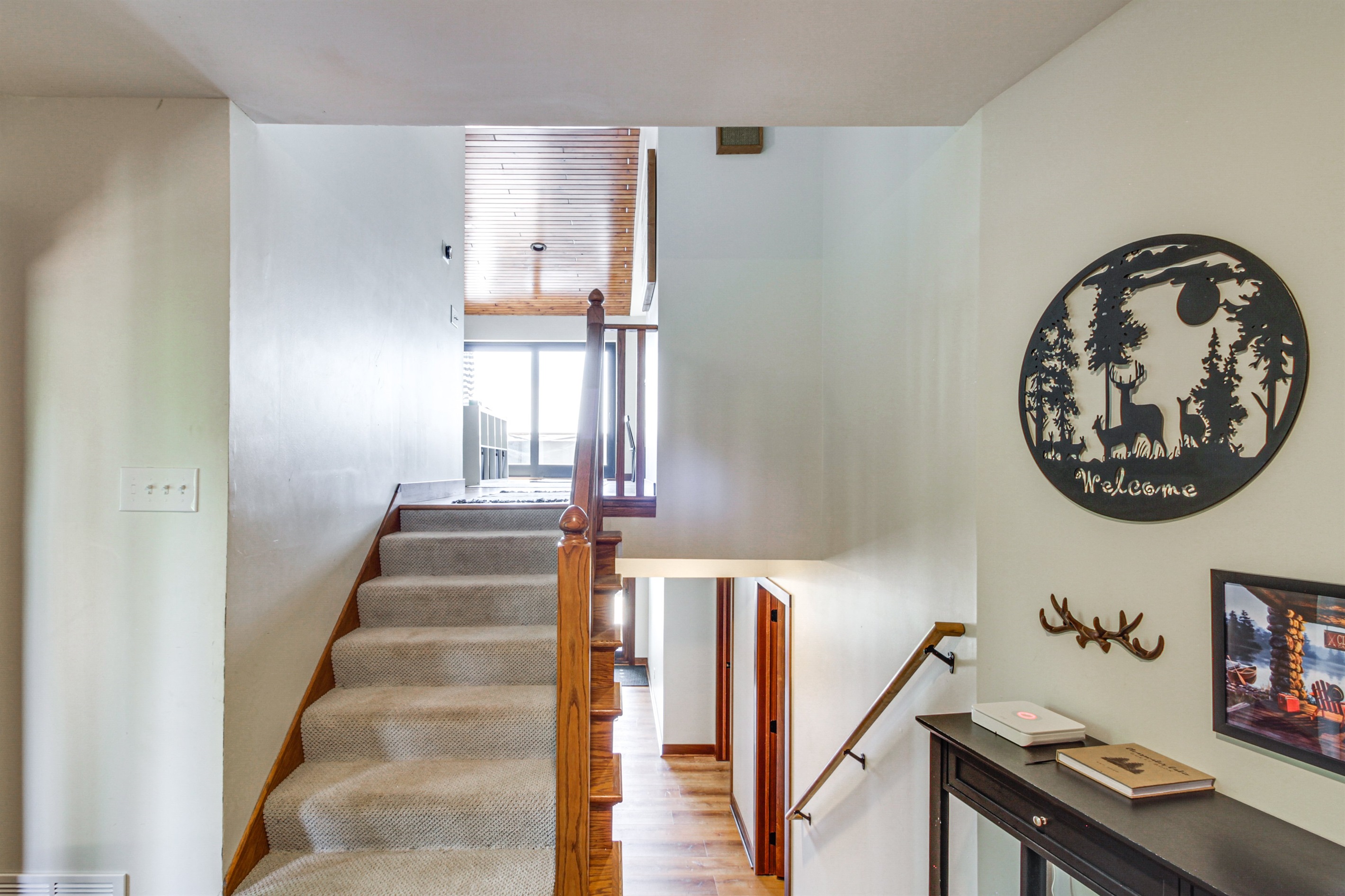 Entryway with staircase leading to upper living areas and lake-view windows beyond