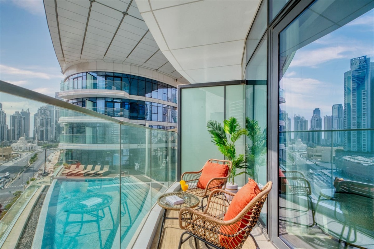 Enjoy your morning coffee on this stylish balcony with a refreshing pool view.