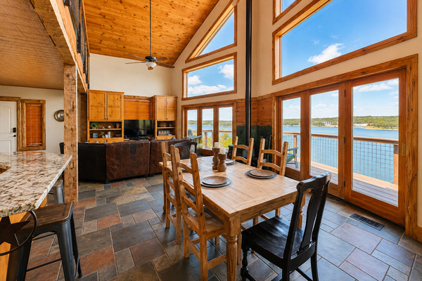 Lakefront dining with panoramic Lake Travis views, soaring windows, and direct access to the expansive deck.