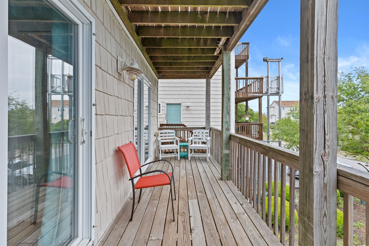 Spacious wraparound balcony with cozy seating and a breezy coastal vibe
