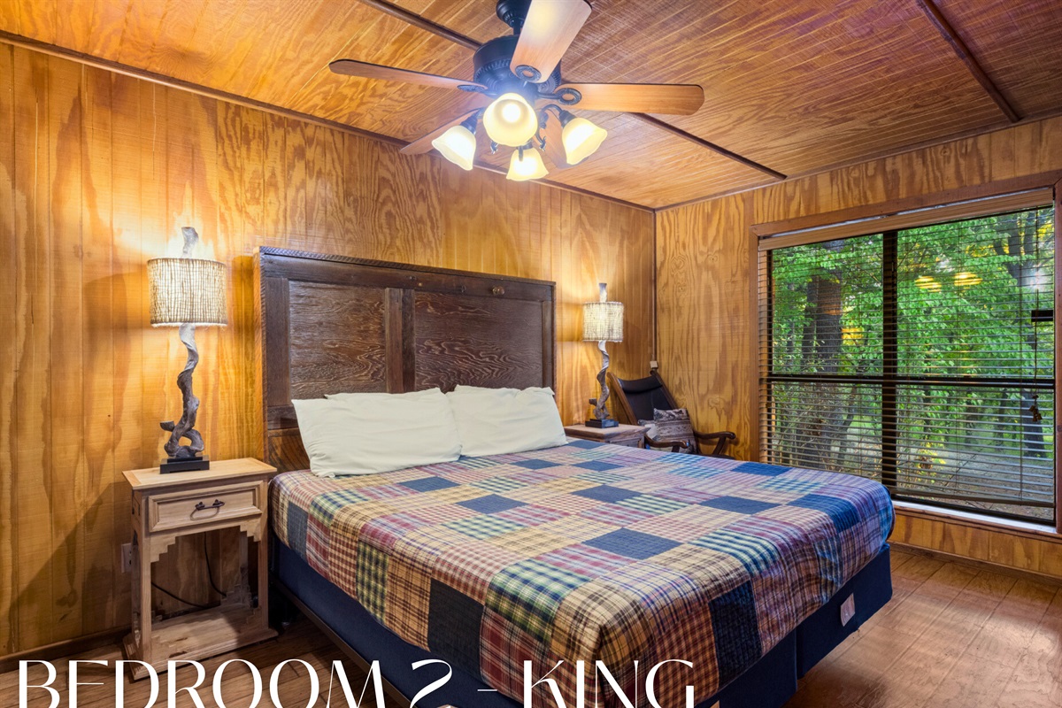 Bright bedroom with king bed and forest views.