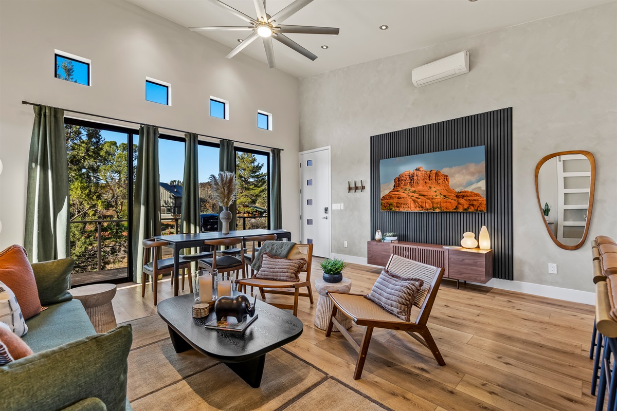 A bright, open living room with high ceilings, large windows, and comfortable seating - designed to bring in natural light and Sedona’s outdoor scenery.