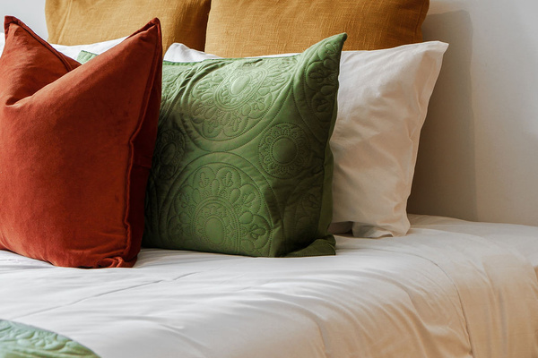 The close-up bed detail highlights a quiet, restful bedroom setting with soft lighting and warm textures at Fernhill Mountain Escape.