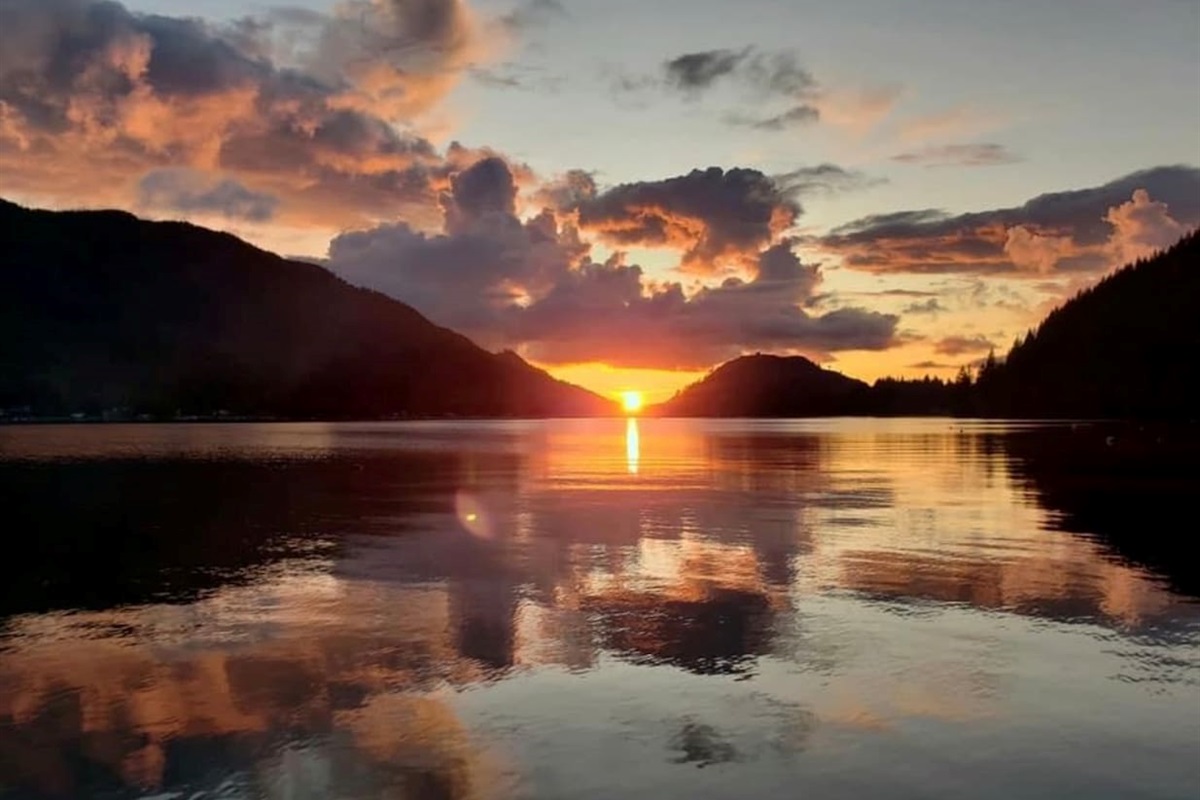 Sunset over the lake and mountains with vibrant colors.