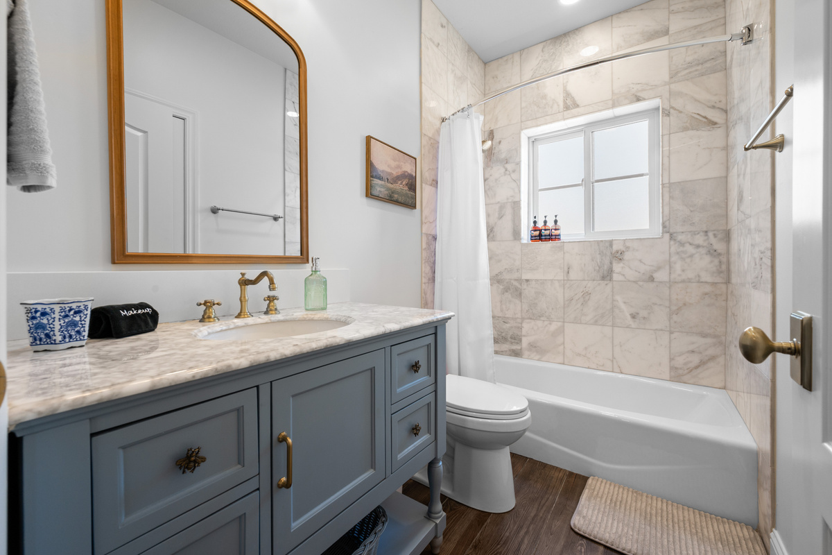 This refined bathroom pairs a spacious vanity with elegant fixtures, a relaxing tub, and tile surrounds for a clean, elevated finish.
