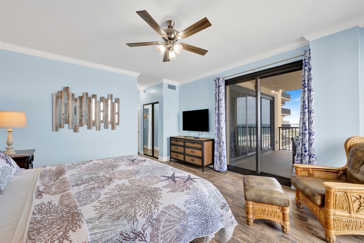 Primary bedroom with king bed, ceiling fan, wall mounted smart TV, direct balcony access and AMAZING view!