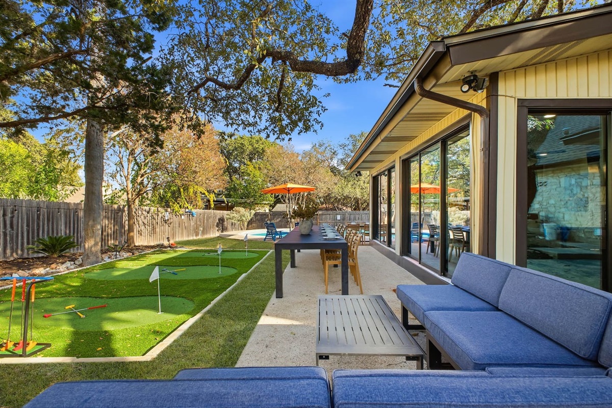 Outdoor couch and dining table located beside the putt-putt course