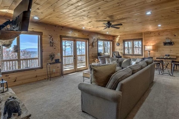 Lower-level living room with plush seating, wide windows, and a relaxed layout - perfect for movie nights or quiet downtime.