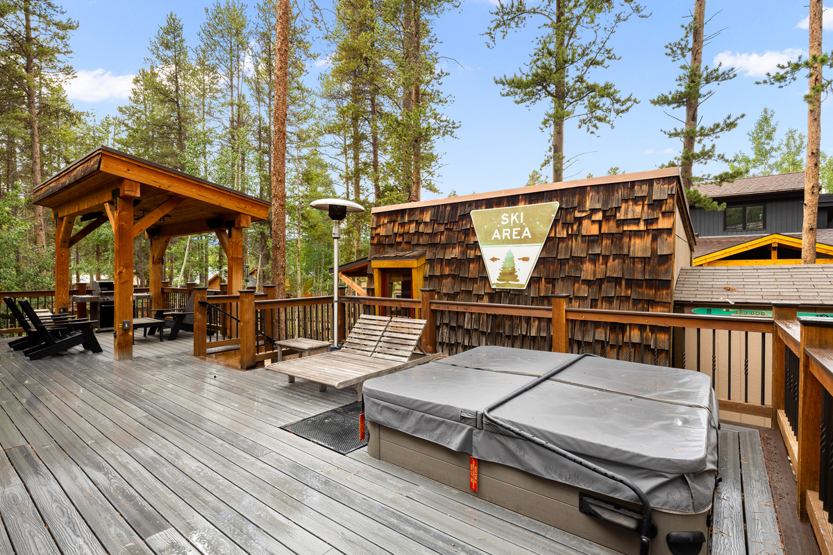 Outdoor living space with expansive deck, covered seating by bar-b-que grill, loungers, outdoor heating and in-ground hot tub. 