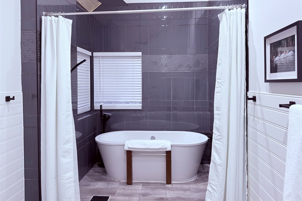 Primary ensuite bathroom featuring both a walk-in shower and relaxing soaker tub