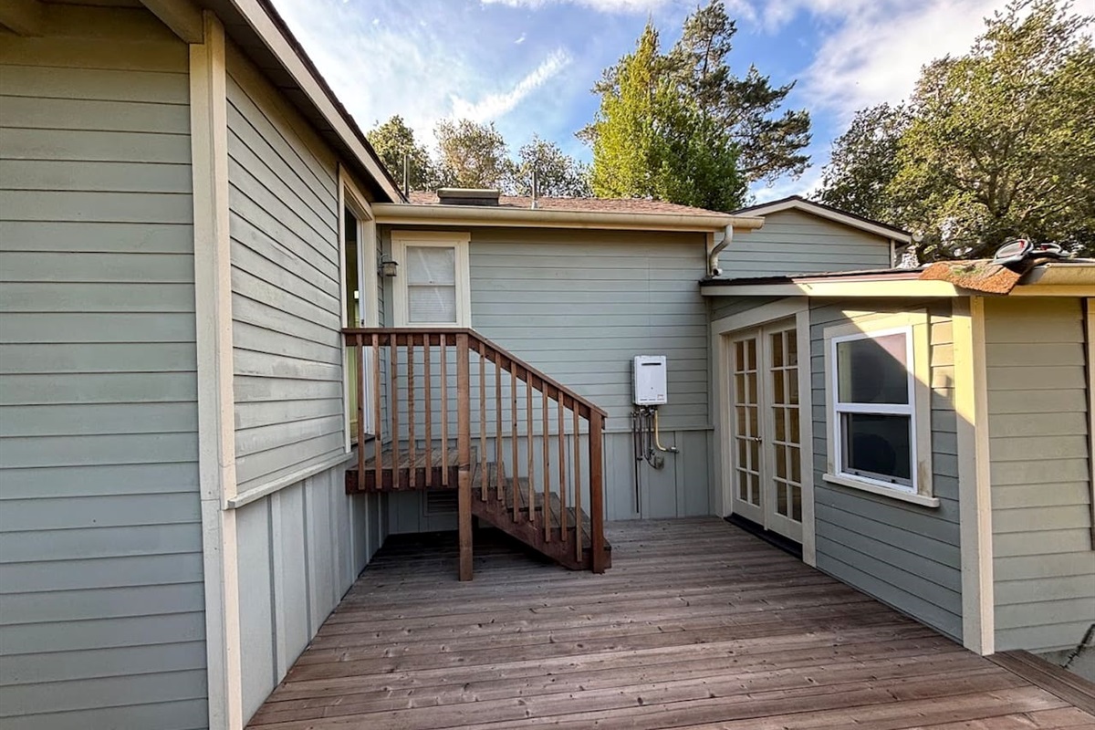 Back deck. Door on left (top of steps) leads to back bedroom, door on right leads to the laundry room.