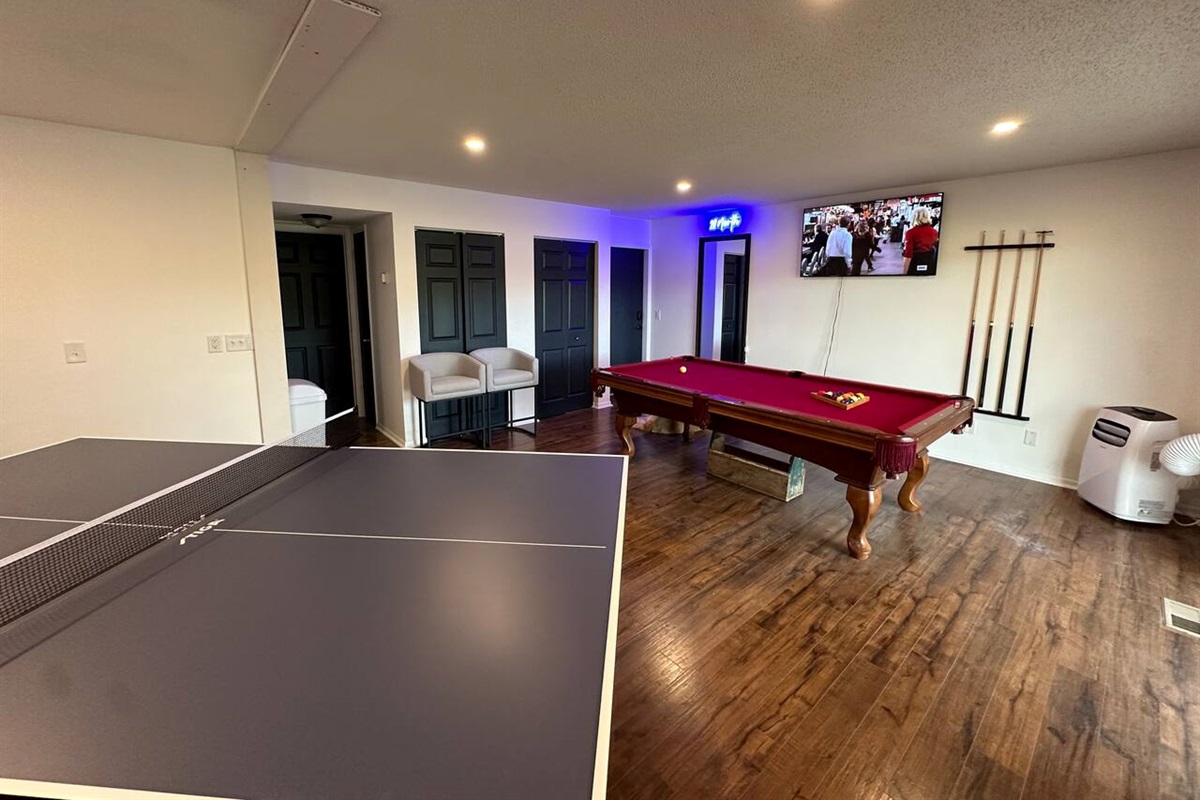 Spacious shared game room with pool table, ping pong, Connect 4, TV, board games and casual seating—perfect for relaxing or friendly competition after a day of adventure. Great for groups and families looking for fun during their stay!
