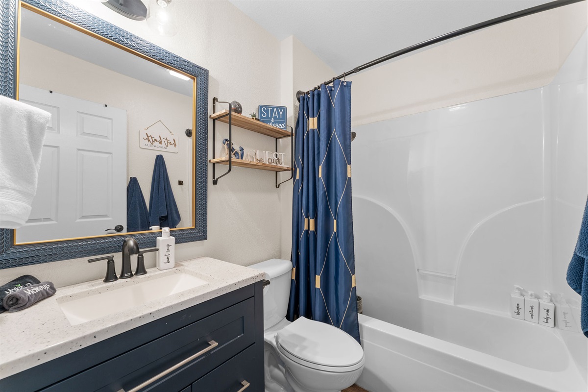 Updated bathroom with modern vanity and tub/shower combo.