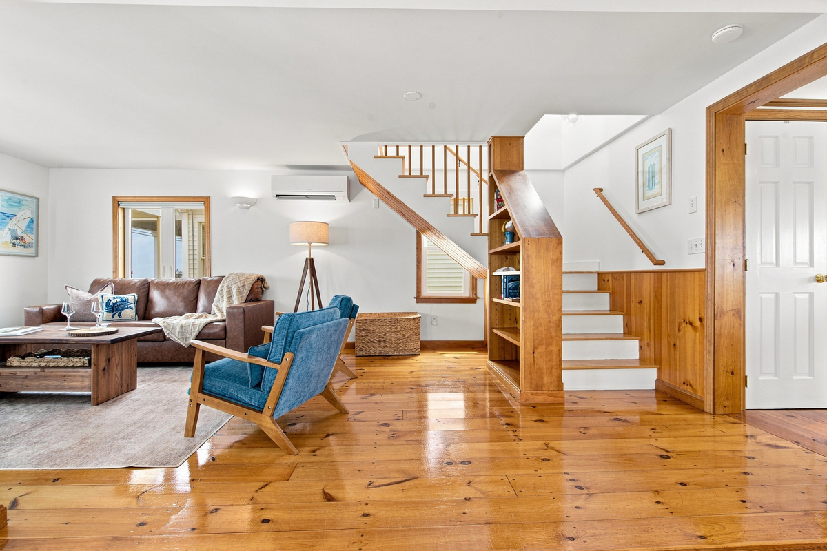 Spacious open living area with warm wood floors and a bright, airy layout.