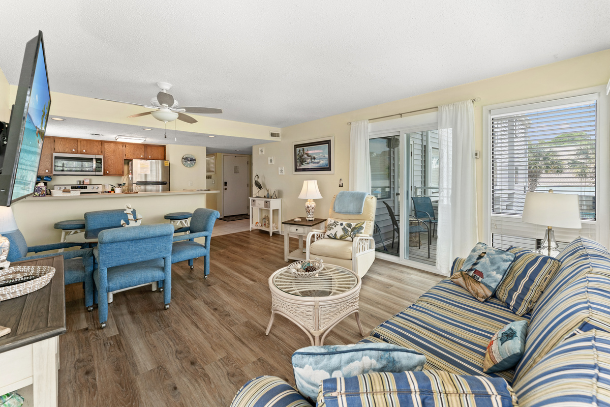 Spacious Living Room area with large TV and balcony access
