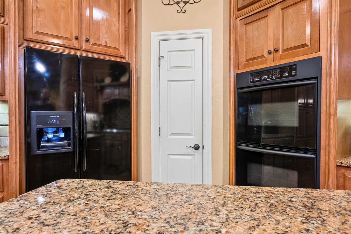 Granite island with plenty of prep space and pantry access.