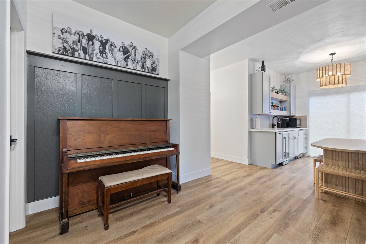 Downstairs entry with the original piano left in the home. This entry also includes a massive closet for guests to store their luggage.