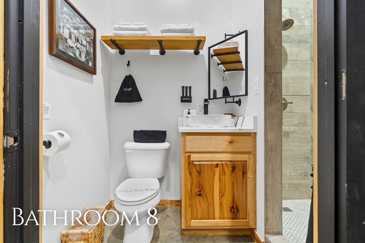 Bathroom 8 offers a practical yet polished space, complete with warm wood accents and a roomy shower.