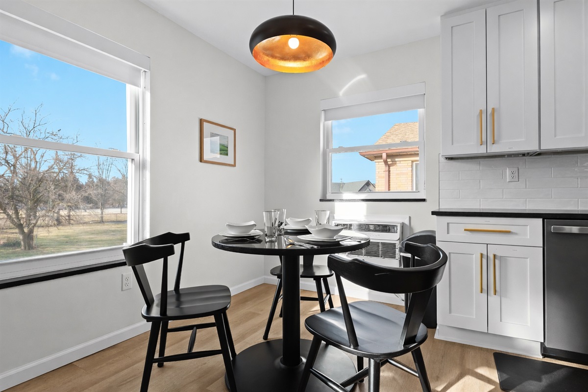 Sunlit dining nook with stylish lighting, cozy seating, and bright windows—perfect for enjoying meals, morning coffee, or relaxed conversations.