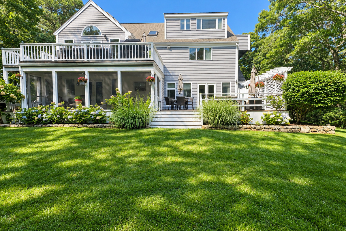 Back of home with screened porch and decks