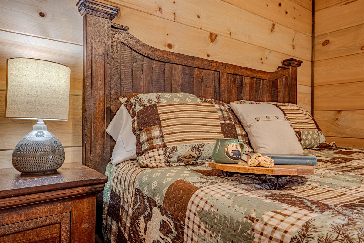 Cozy king bedroom with warm cabin décor and plush bedding.
