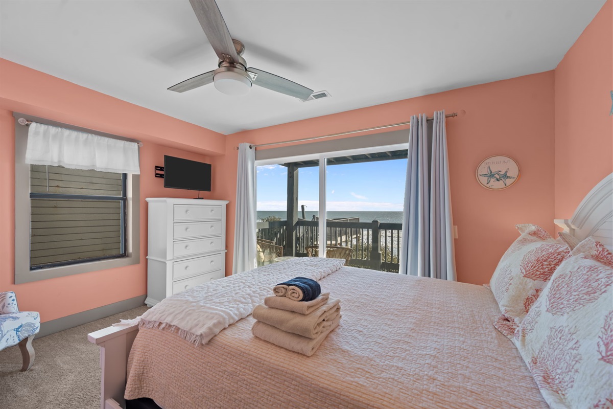 Comfortable Queen bed, soft coastal d&eacute;cor, and sliding doors leading to the oceanfront balcony for fresh air and beautiful views