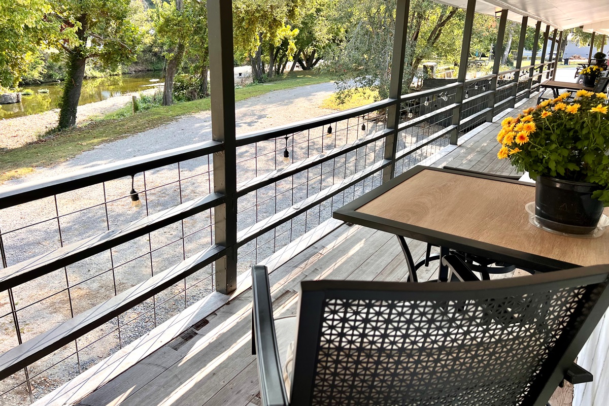 Cozy outdoor seating outside your door with a creek view.