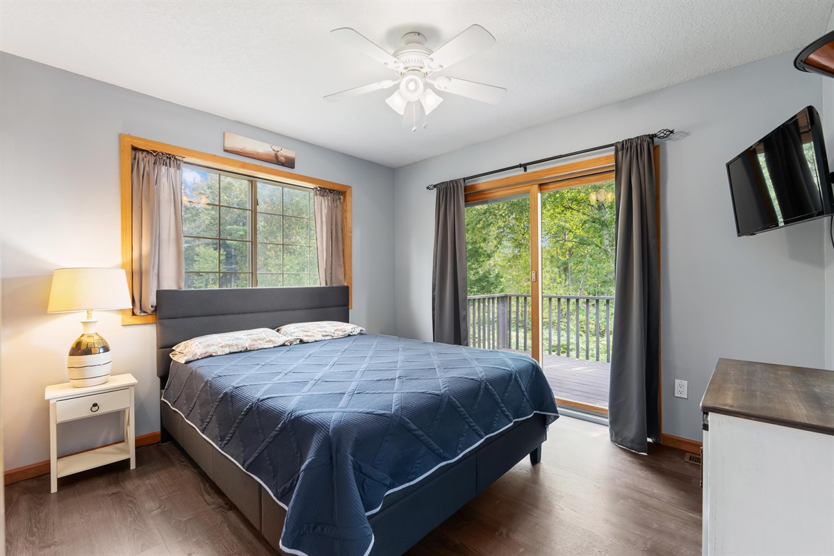 Bedroom 1 with Queen sized bed overlooking the river and slider doors leading to the deck