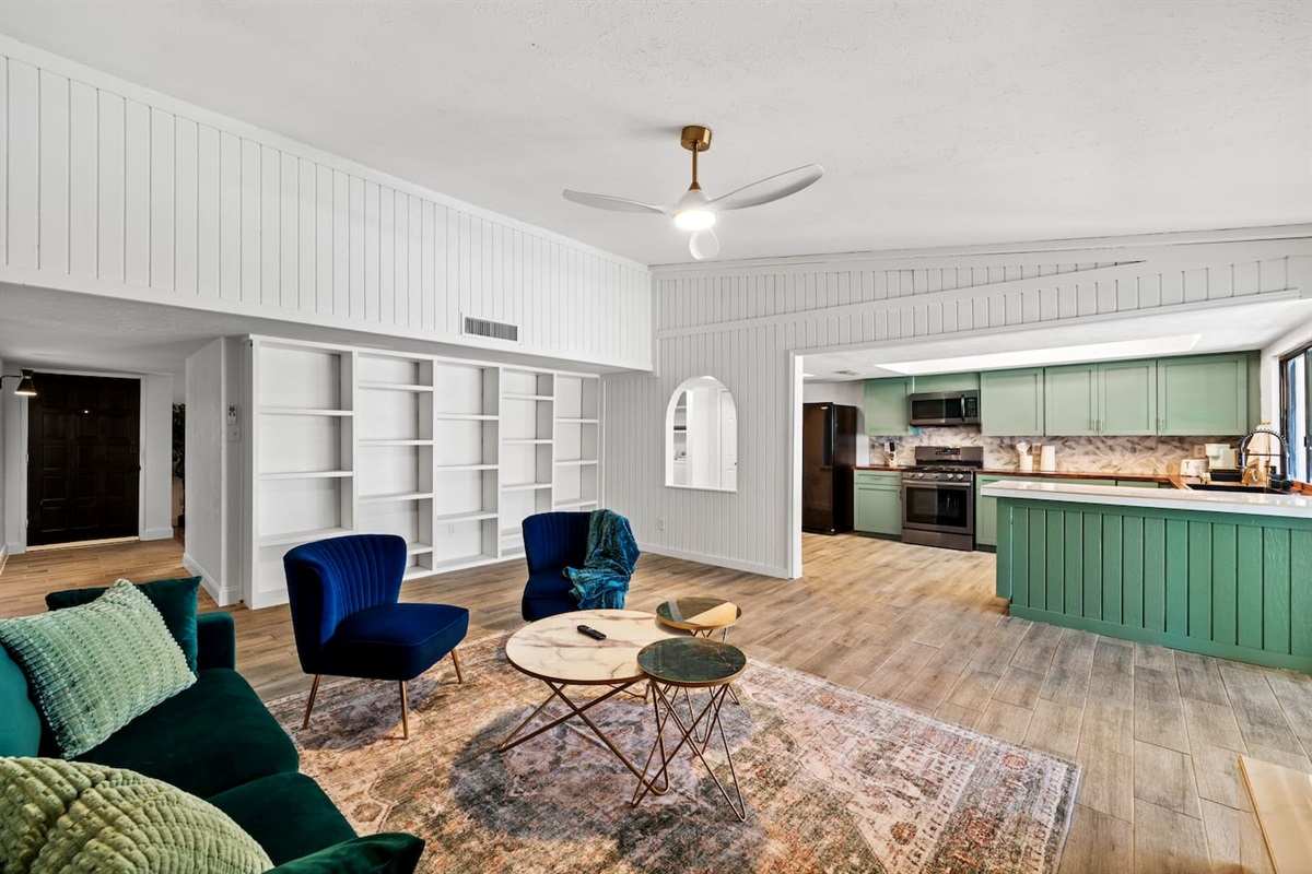 Chic and cozy living room with vibrant velvet seating, statement decor, and open shelving—perfect for relaxing or hosting in style.