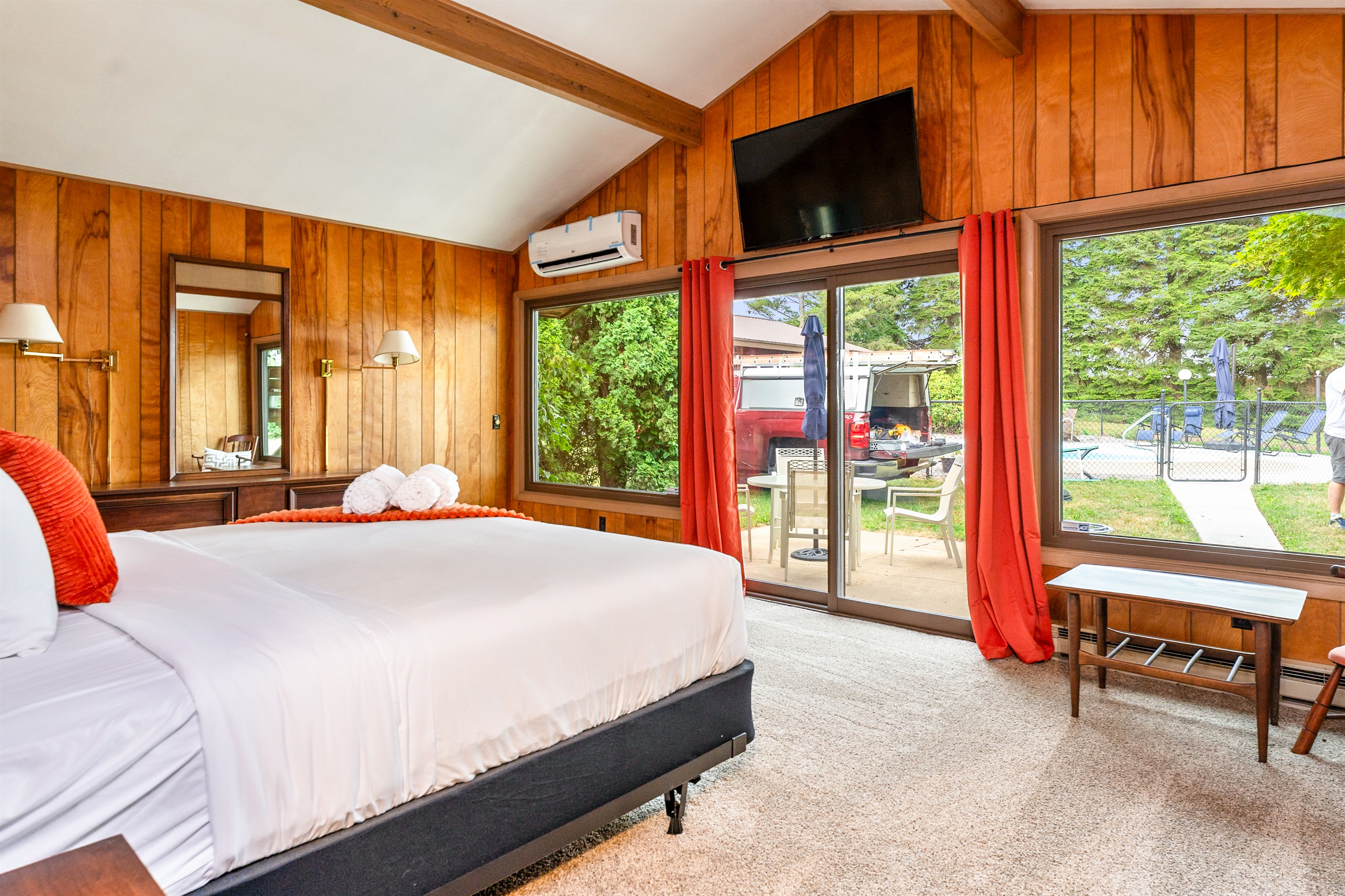 Spacious bedroom with a king bed, vaulted ceiling, and direct patio access for fresh air and poolside relaxation.